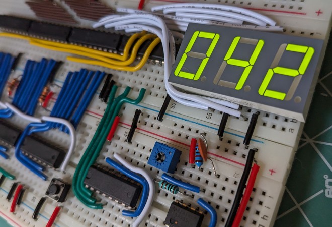 A digital counter built on a breadboard, with its LCD display showing the number 42